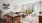 Staged living room featuring a designated dining area, tan couch, coffee table, white chair, and sliding door leading to a private terrace.