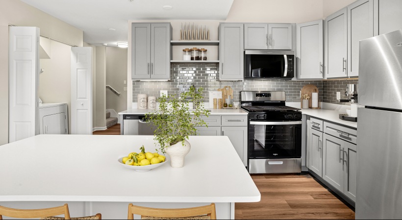 Newly renovated apartment for rent The Prescott at Concord featuring a view of the new modern kitchen cabinetry, quartz countertop island, stainless steel appliances, and hardwood flooring.