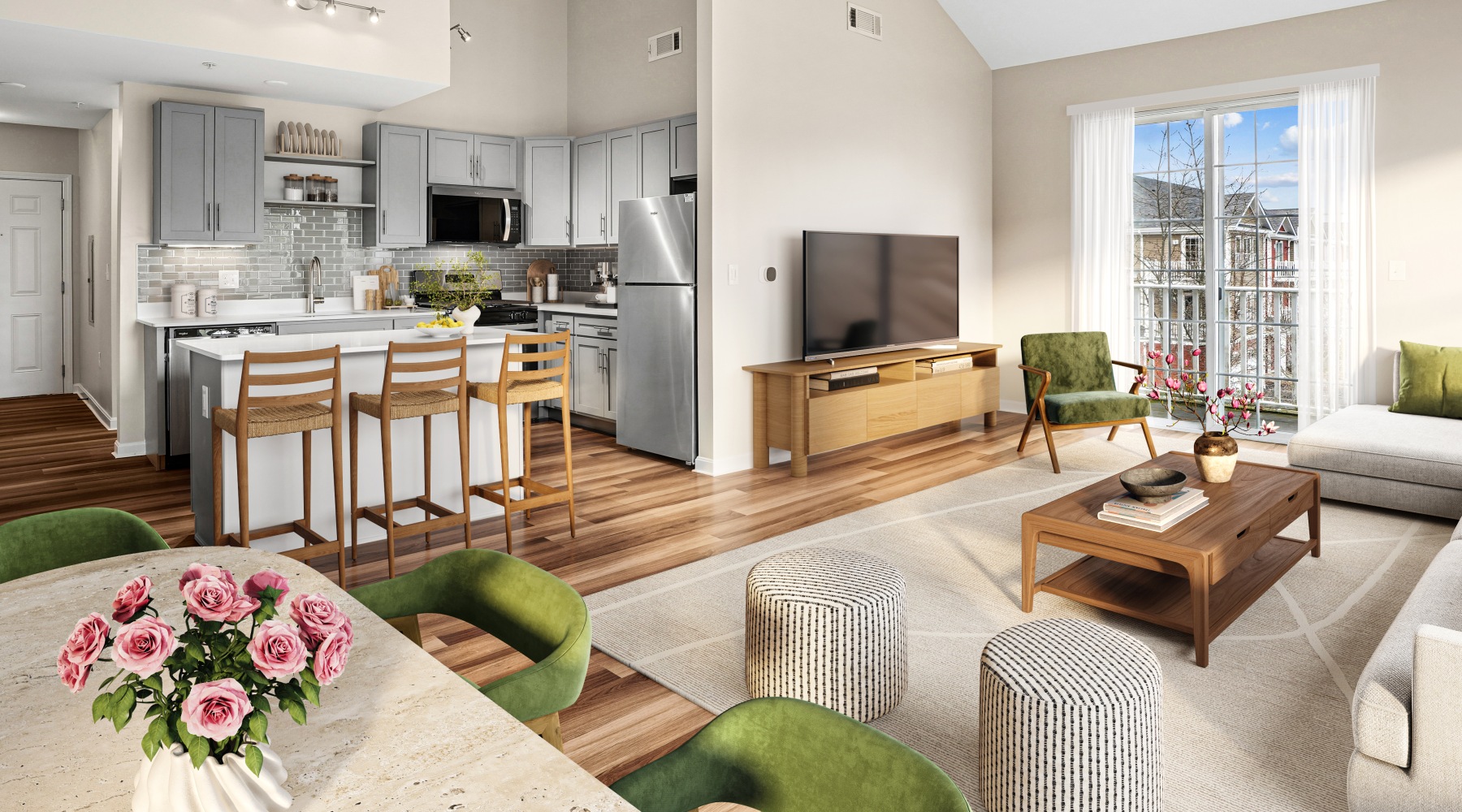A furnished living room with a couch, dining table, and view of kitchen with island and barstools.
