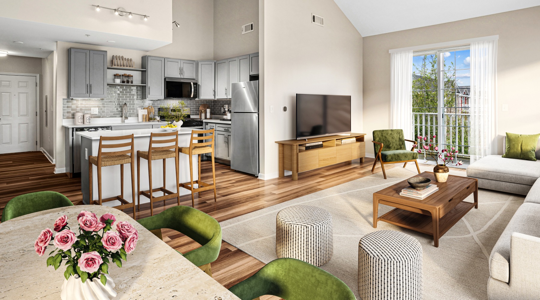 A furnished living room with a couch, dining table, and view of kitchen with island and barstools.